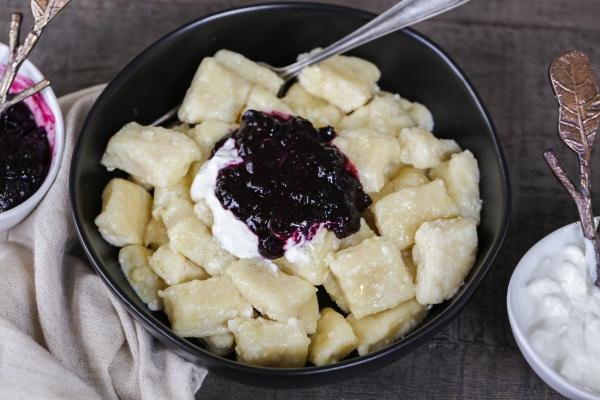 Pierogi « paresseux » dans un bol avec de la confiture et de la crème sure
