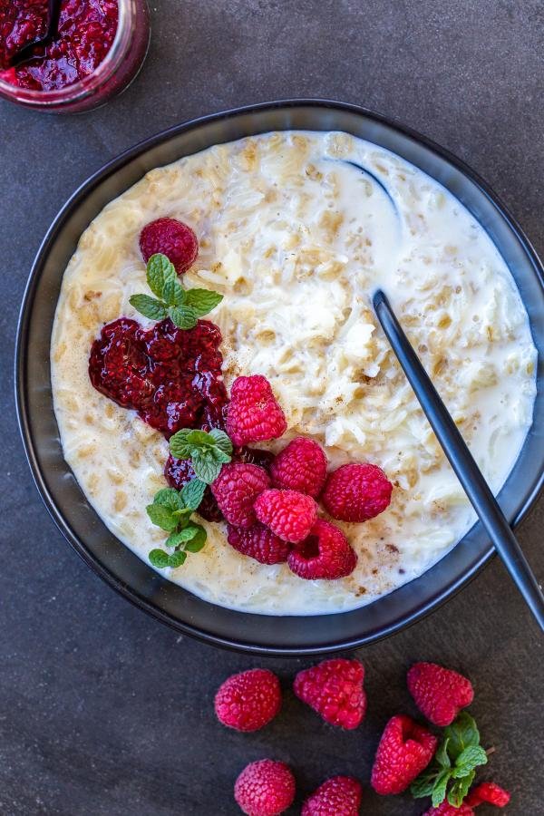 Riz au lait à l'ancienne dans un bol avec des baies et de la confiture
