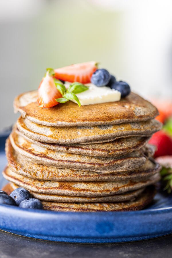 Une assiette avec des crêpes de sarrasin et des baies.