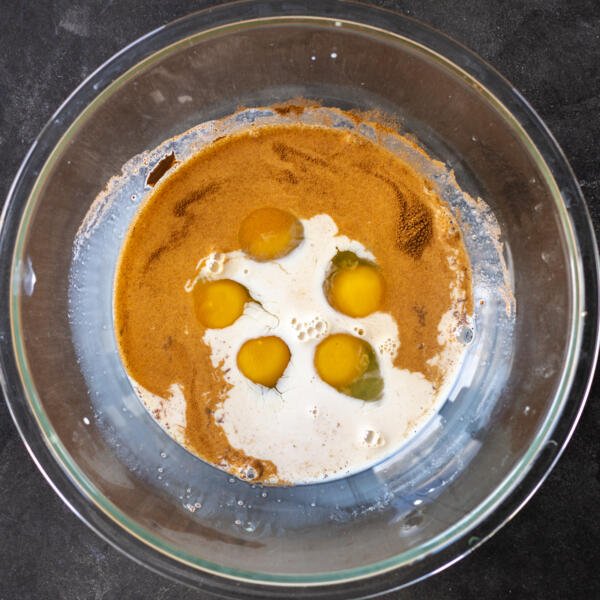 Œufs, cannelle, vanille et lait dans un bol.