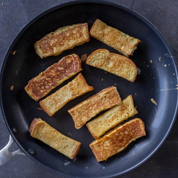 Bâtonnets de pain perdu dans une poêle.