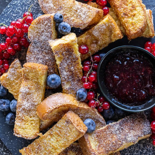 Bâtonnets de pain perdu sur un plateau avec des fruits rouges.