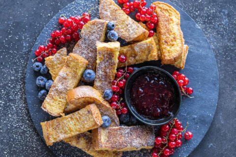 Bâtonnets de pain perdu avec des fruits rouges sur un plateau de service.