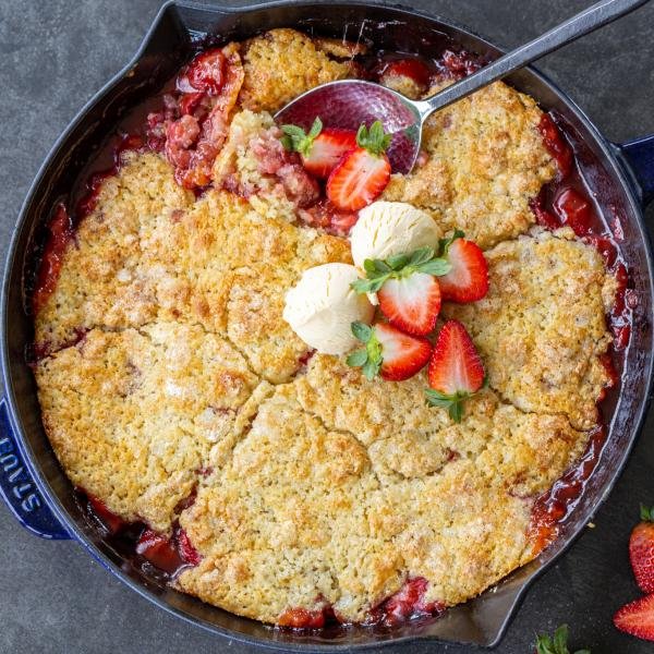 Crumble aux fraises dans un plat avec des baies et de la crème glacée