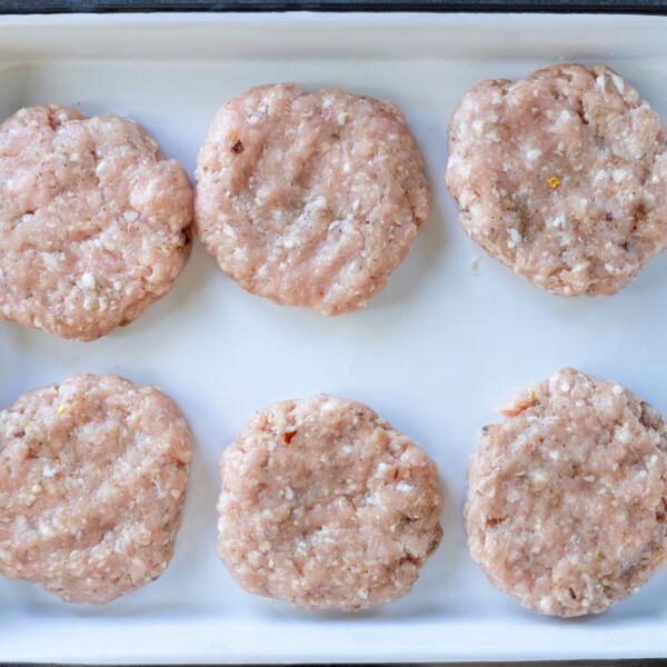Galettes de saucissons maison façonnées sur un plateau.