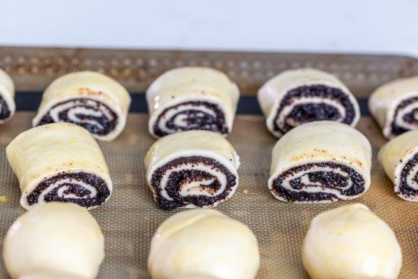 Pâte roulée avec garniture aux graines de pavot sur une plaque à pâtisserie
