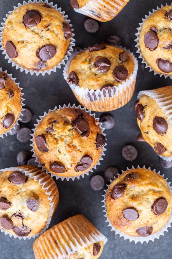 Muffins aux bananes et pépites de chocolat avec du chocolat autour.