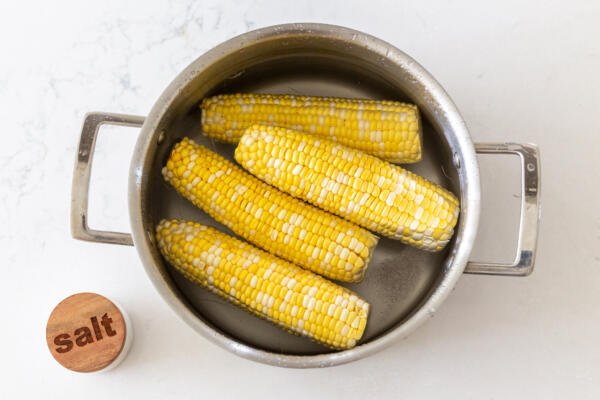 épis de maïs dans une casserole avec du sel et de l'eau