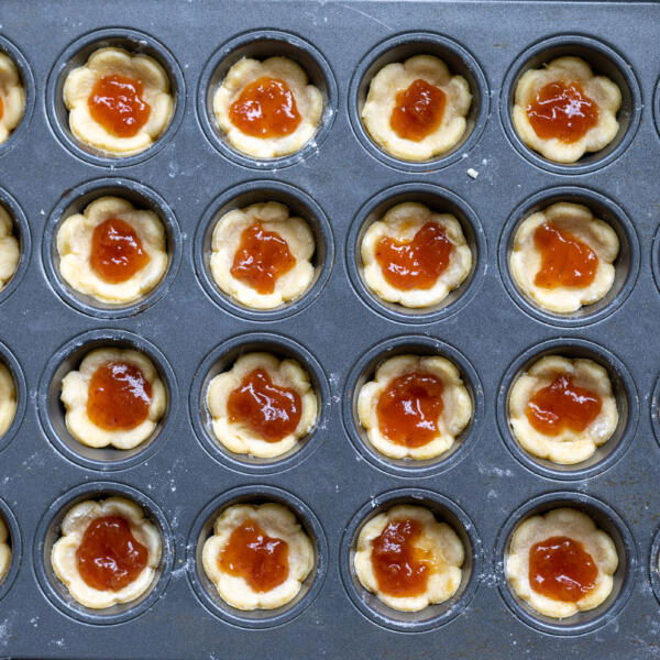 Pâte dans un moule avec de la confiture au centre.