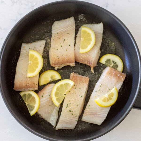 halibut avec du citron et des épices dans une poêle.